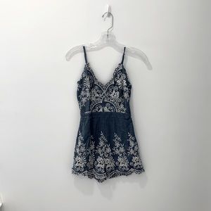 Simplee denim romper with flower detail. Zipper on the back.